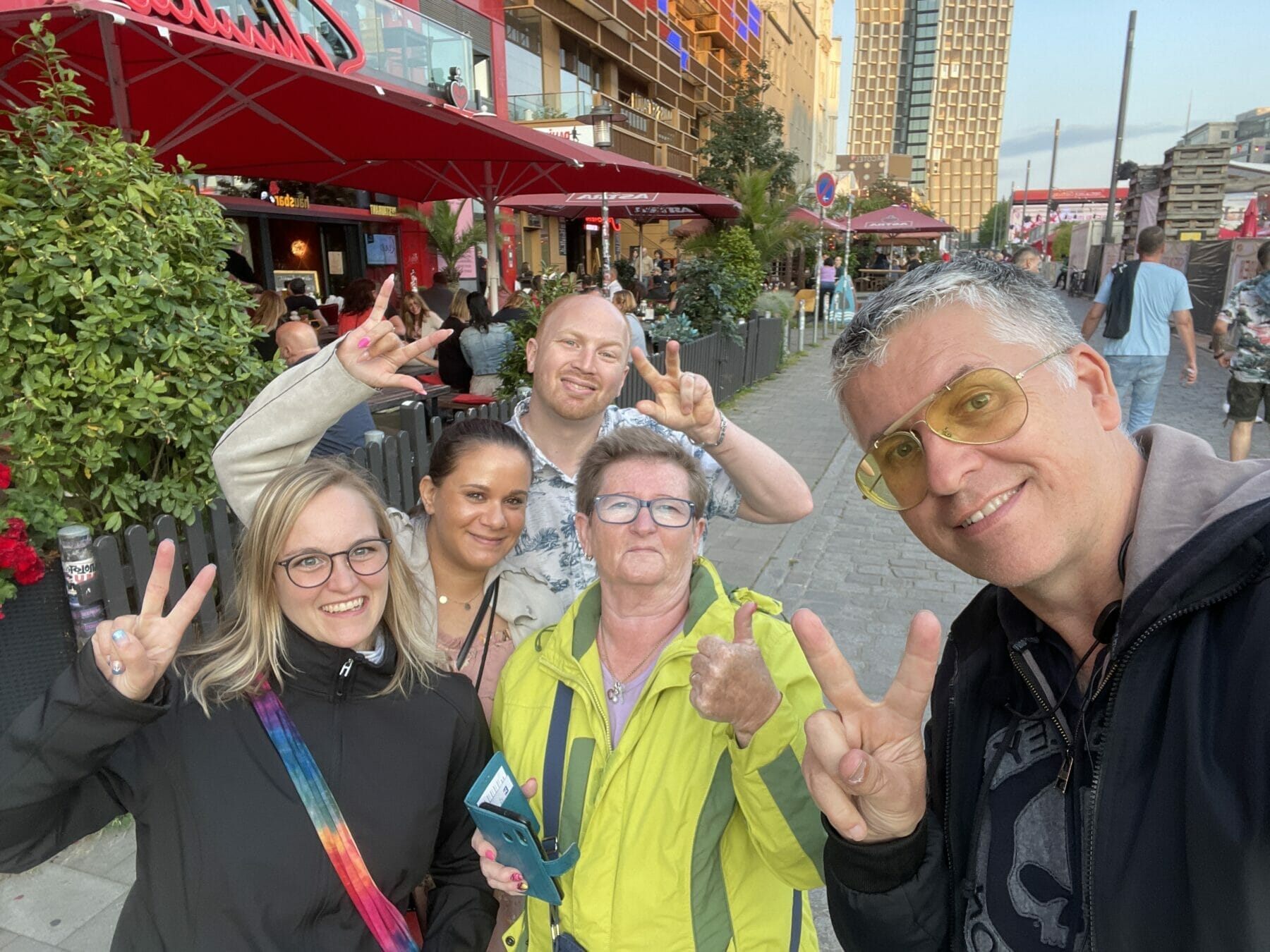 Fünf Freunde zeigen Peace-Zeichen beim Fotografieren.