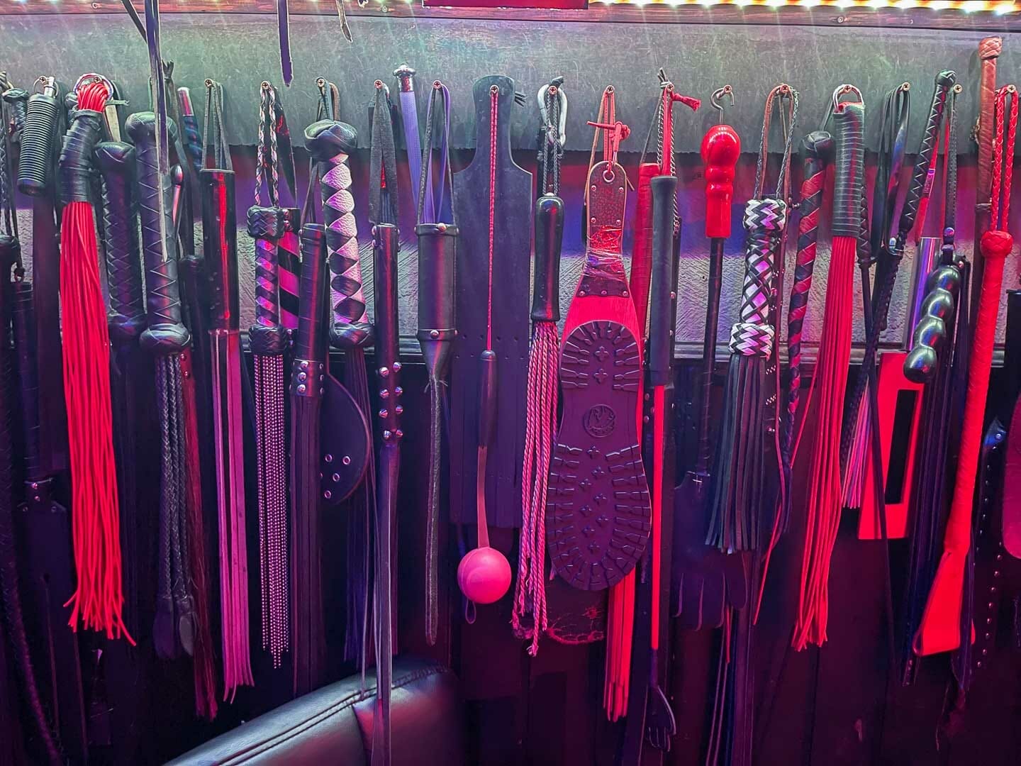 Verschiedene Bondage- und Fesselspielzeuge an einer Wand
