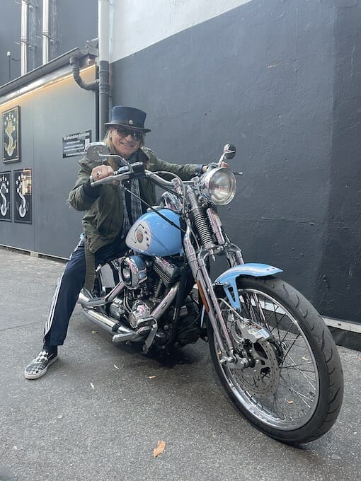 Mann auf einer blauen Motorradmaschine.