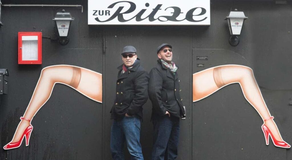 Zwei Männer vor einem Restaurant mit Wandkunst.